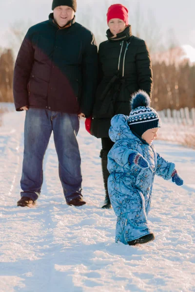 Mamma e papà sono in piedi a guardare il suo bambino passeggiare vicino — Foto Stock