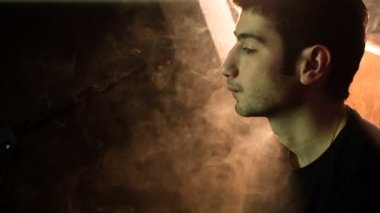 Adam bir nargile sigara içiyor.