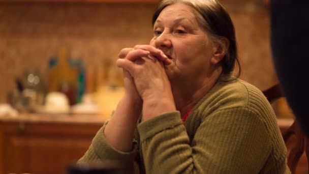Пожилая женщина грустные руки скреплены вместе и его локти на столе — стоковое видео