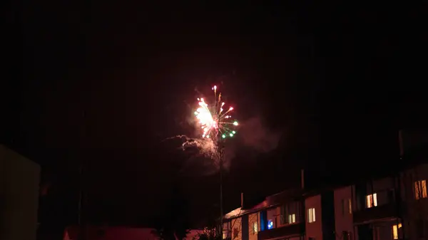 Fuochi d'artificio nel cielo notturno sopra le case — Foto Stock