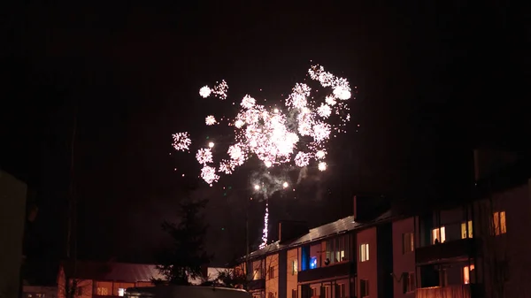 Fuochi d'artificio nel cielo notturno sopra le case — Foto Stock