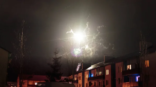 Fuegos artificiales en el cielo nocturno sobre casas — Foto de Stock