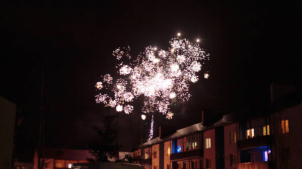 fireworks in the night sky over houses
