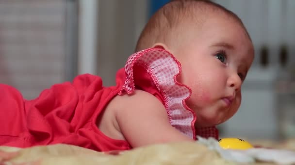 柔らかい表面および演劇の上に横たわる小さな女の赤ちゃん. — ストック動画