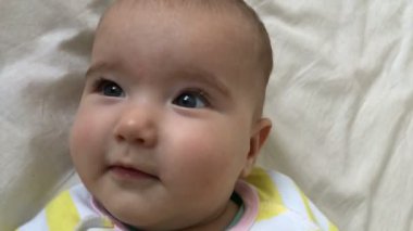 Küçük bebek yatıyor ve başını ağır çekimde katlanmış.