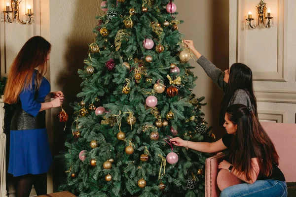 Tres hermosas chicas jóvenes cerca del árbol de Navidad. Estudio horizontal retrato . —  Fotos de Stock