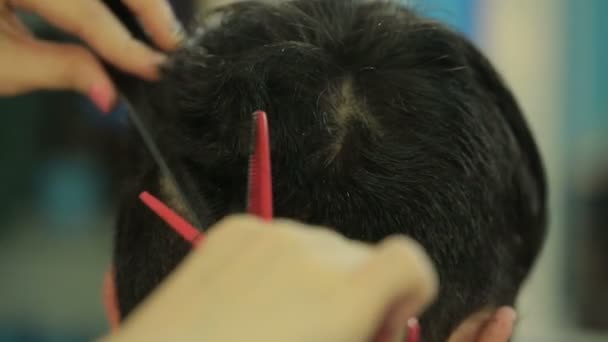 Barber zastřihne vlasy klienta s nůžkami. — Stock video