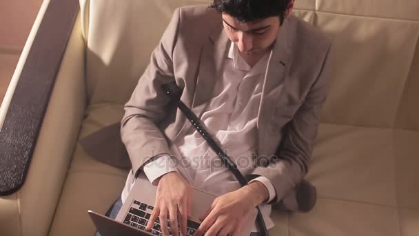 Affärsman röka vattenpipa och arbetar på en bärbar dator. — Stockvideo