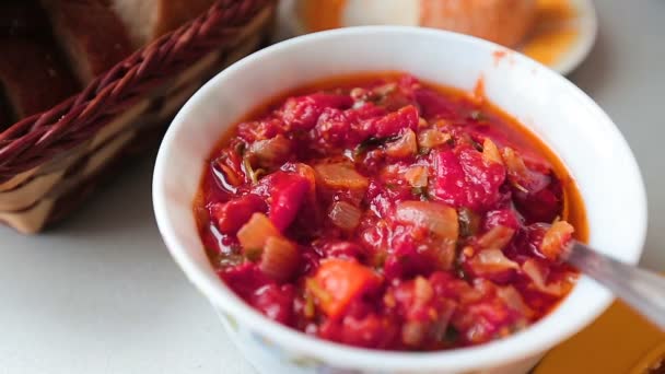 Red soup in a bowl on the kitchen table. — Stock Video