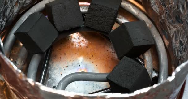 Kokos-houtskool voor waterpijp verwarmd op een elektrische spiraal. — Stockvideo