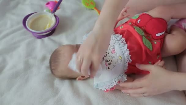 Mãe limpa a boca com um bebê pequeno . — Vídeo de Stock