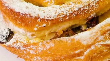 Üzümlü çörek beyaz bir arka plan üzerinde döner.