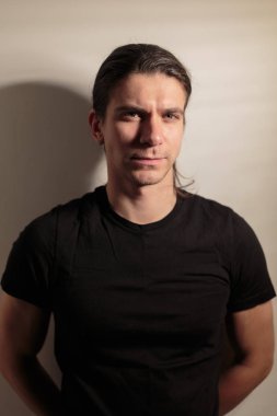 Siyah uzun saçlı acımasız adam.