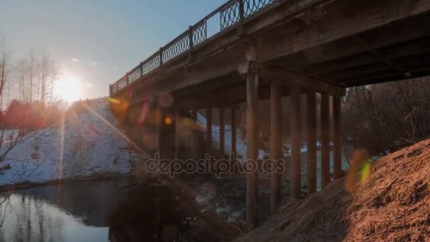 Movimiento del río bajo el puente sobre el telón de fondo del sol brillante. Video de lapso de tiempo . — Vídeos de Stock