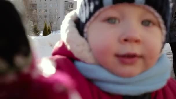Ansiktet av en liten pojke med mycket uttrycksfulla ögon i vinterkläder. — Stockvideo