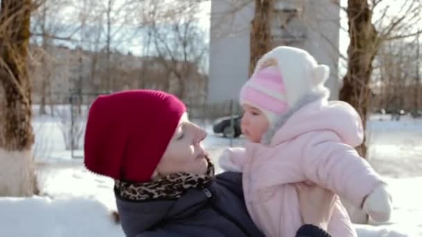 Mamá y su pequeño bebé en la calle en el invierno durante el día . — Vídeo de stock
