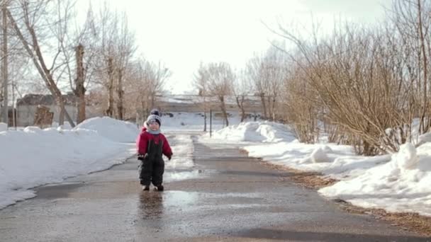 Liten pojke i vintern på väg på dagtid. — Stockvideo