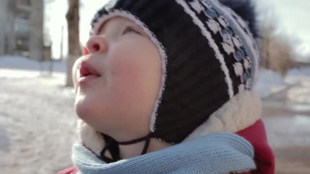 Visage d'un petit garçon aux yeux très expressifs en vêtements d'hiver . — Video