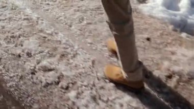 Kamera kirli karda öğleden sonra olduğunu insan ayağı sürdürür.