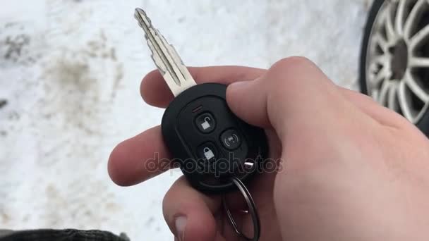 Hand bedrijf auto sleutels en drukt op de alarmknop eerste persoonsmening. — Stockvideo