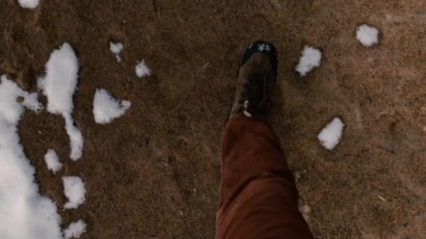男は、ときにすべての雪がまだ溶けていない春先の砂に沿って歩きます。最初人の眺め. — ストック動画
