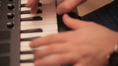 Denetleyici bir MIDI klavye synthesizer oynarken adam eller.