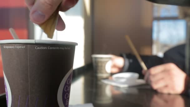 Hand pours sugar into a disposable cup after stir. — Stock Video