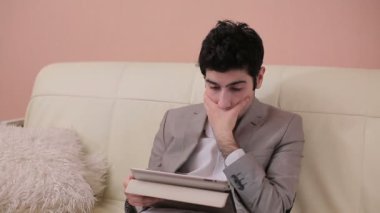 Genç işadamı metin tablet içinde dikkatle okur.