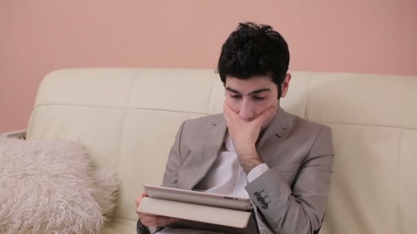 Young businessman reads the text carefully through the tablet. — Stock Video