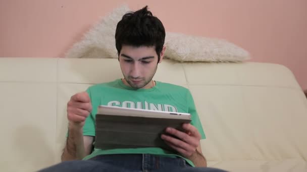 Emotionaler junger Mann arbeitet mit Tablet. — Stockvideo