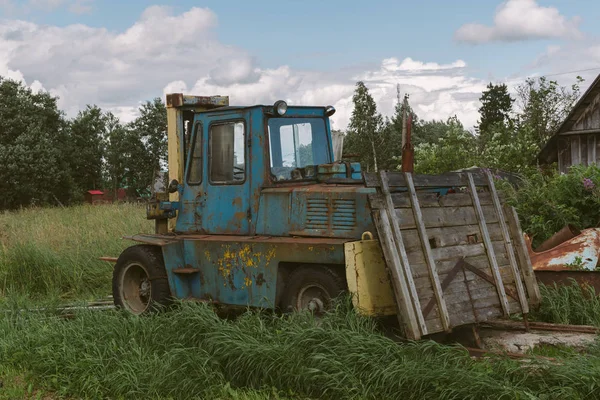 Eski yükleyici araba yeşil bahçesinde.