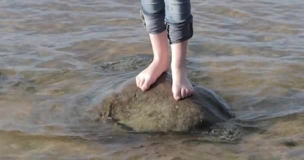 Blote voeten op een steen door het water — Stockvideo