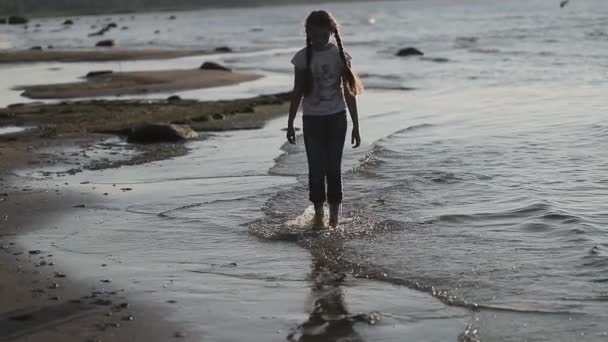 Ung flicka vandring längs stranden i slow motion — Stockvideo