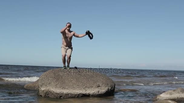Человек прыгает на камне — стоковое видео