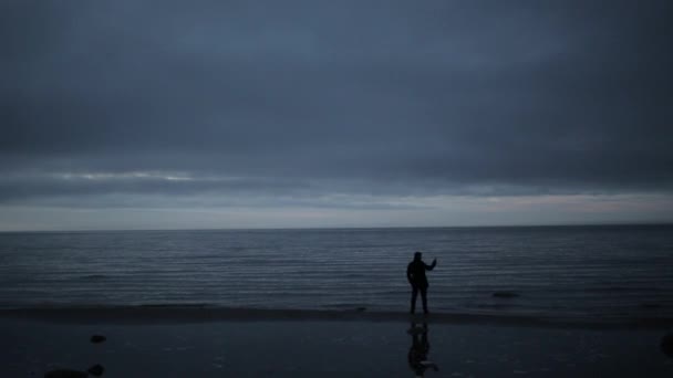 Adam akşam sahilde cep telefonunuzla — Stok video