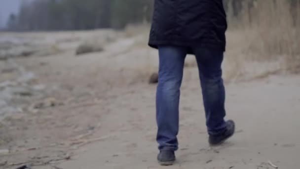 Férfi sétál a tengerpart mentén, az őszi — Stock videók