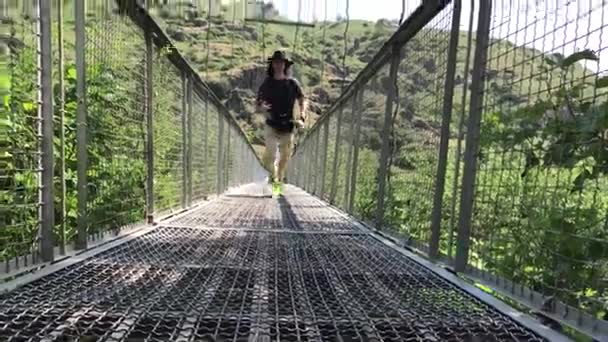 男は、Khndzoresk、アルメニアの吊り橋を歩いています。 — ストック動画