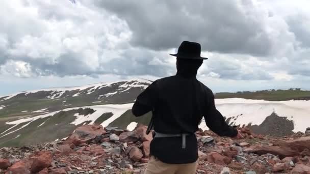 Человек бросает камень в горы в замедленном движении — стоковое видео