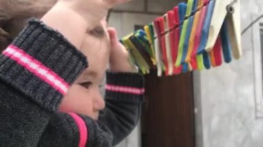 Küçük bebek ve clothespins bir ip üzerinde