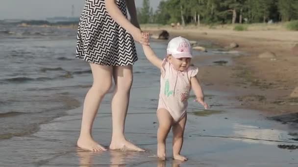 Mor med ett barn på stranden — Stockvideo