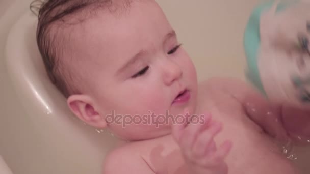 Litet barn i badrummet spelar med en tvättlapp — Stockvideo