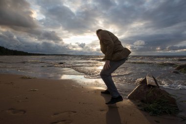 Adam gün batımında sahilde