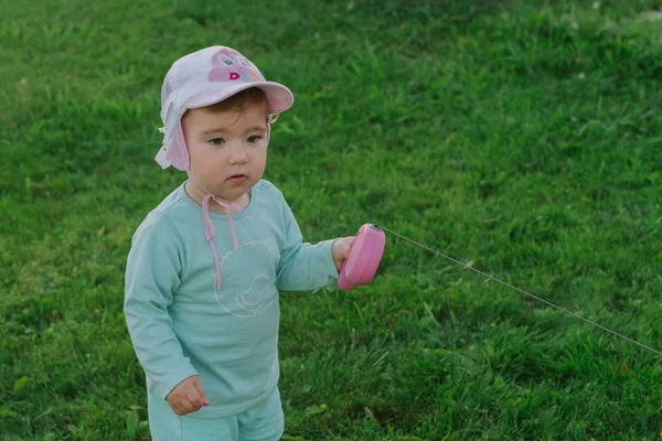 Yeşil bir alanda küçük çocuk bir kurşun elinde tutuyor..
