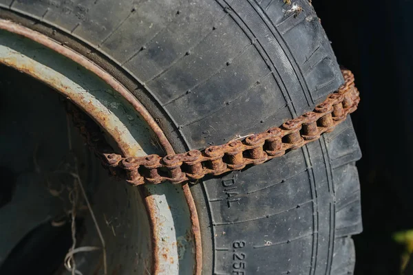 Reifen rollen eine rostige Kette auf. — Stockfoto