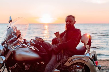 adam bir motosiklet helikopter batımında sahilde