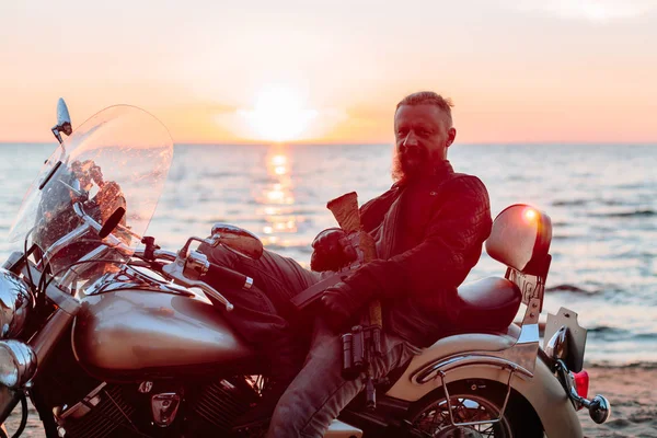 adam bir motosiklet helikopter batımında sahilde