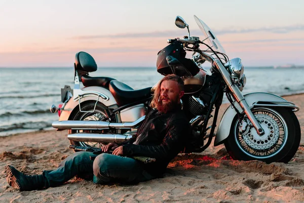 Gün batımında sahilde onun motosiklet yakınındaki motorcu aittir