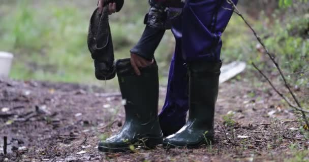 男は森の中濡れたブーツを着ています。 — ストック動画