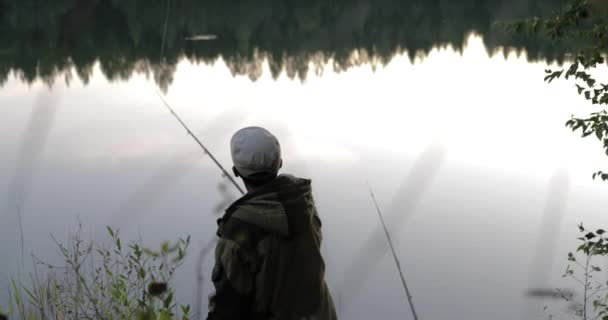 Pescador lanza una caña de pescar en la orilla del río — Vídeo de stock