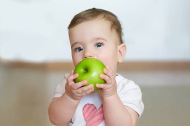 Onun elinde bir yeşil elma ile küçük bir çocuk. Portre kadar kapatın